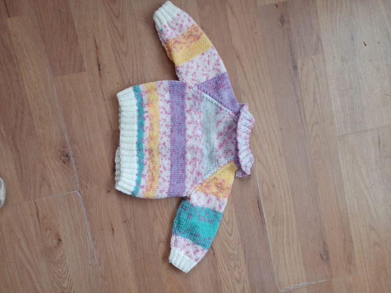 Cardigan hand knitted in soft self patterning yarn.