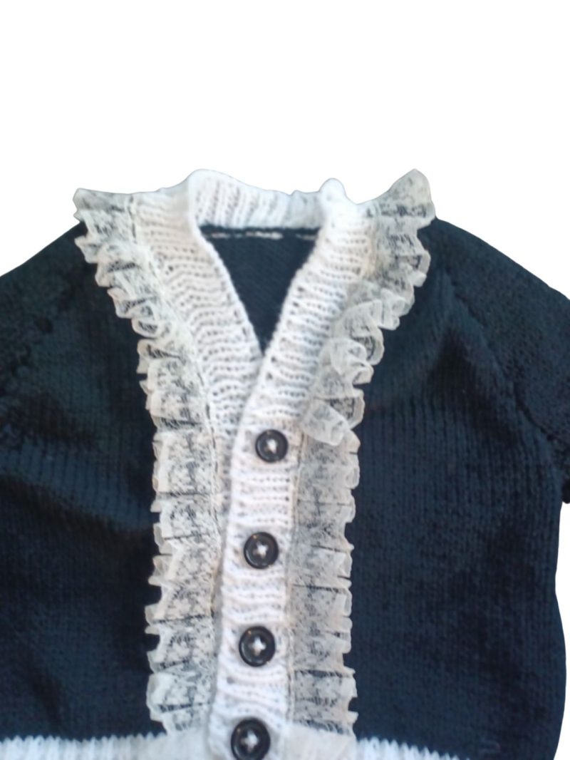 Long sleeved black cardigan with white trim. A lovely lace trim up the front and around the neck can be added. Comes is various sizes. Acrylic yarn for easy care.