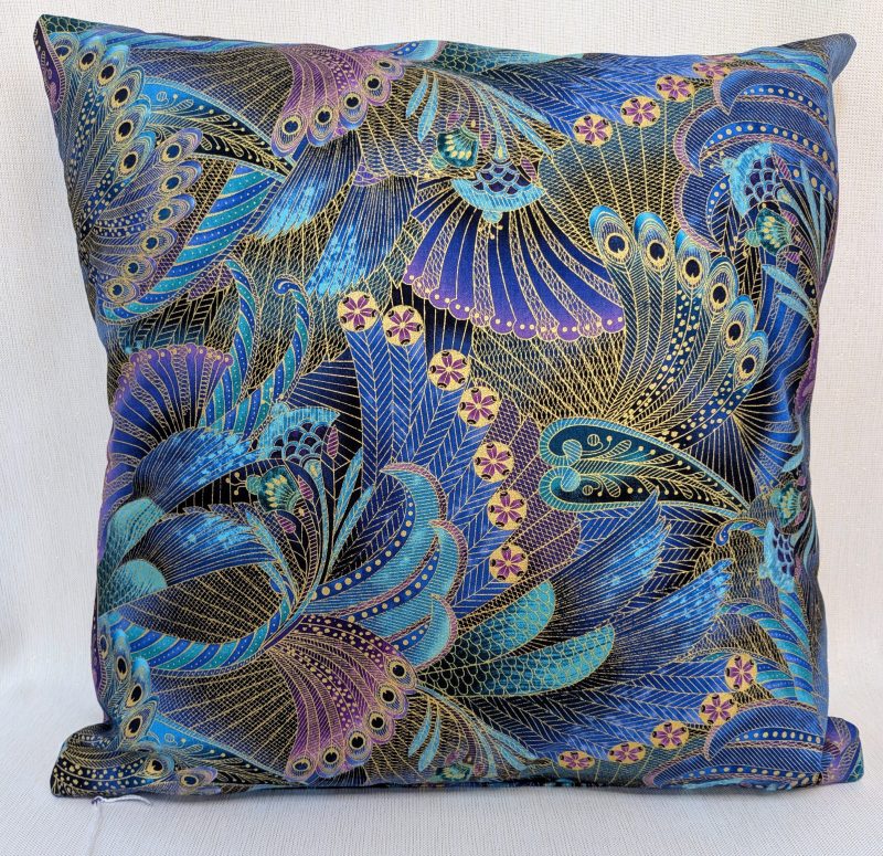 Reverse of decorative cushion cover with intricate peacock feather pattern in blue, purple, and gold on black background, 18 inch, zipped and lined