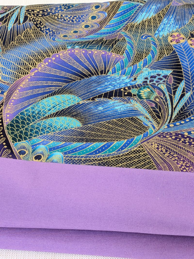 Lining detail of decorative cushion cover with intricate peacock feather pattern in blue, purple, and gold on black background, 18 inch, zipped and lined