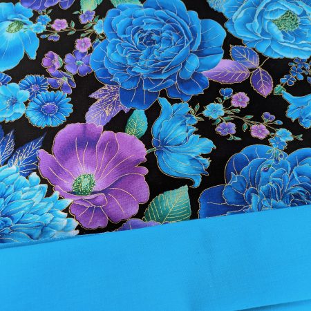 Lining detail of decorative throw pillow cover with vibrant blue and purple floral pattern on a black background, featuring detailed blossoms and leaves.