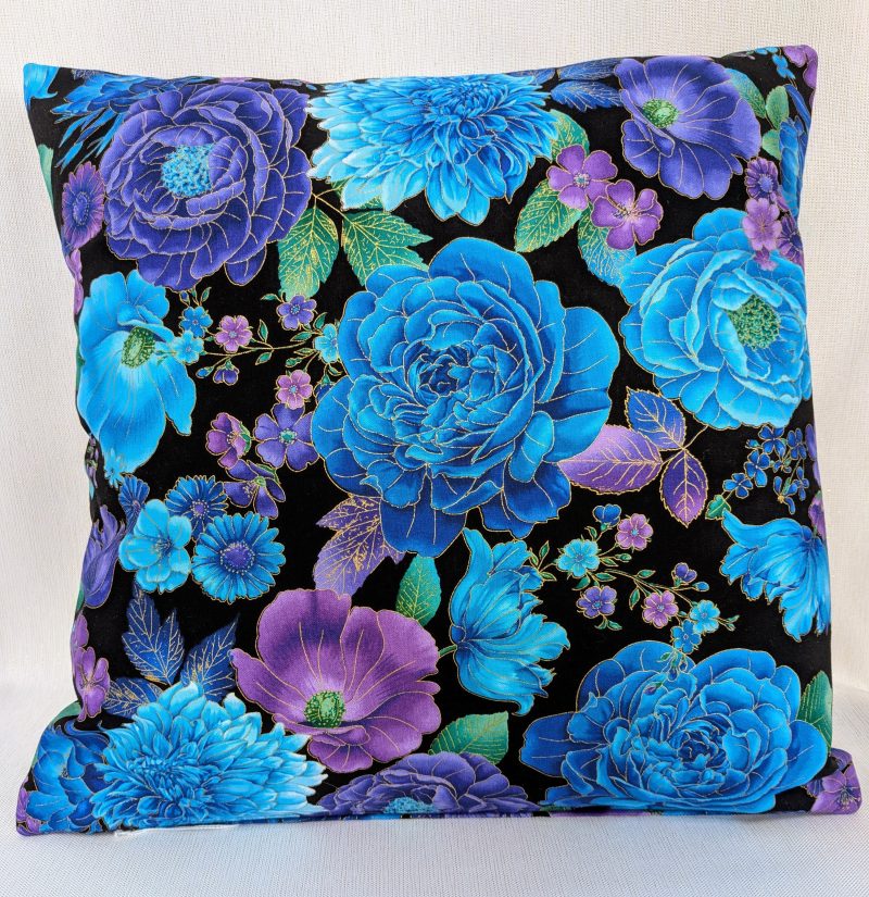 Reverse of decorative throw pillow cover with vibrant blue and purple floral pattern on a black background, featuring detailed blossoms and leaves.