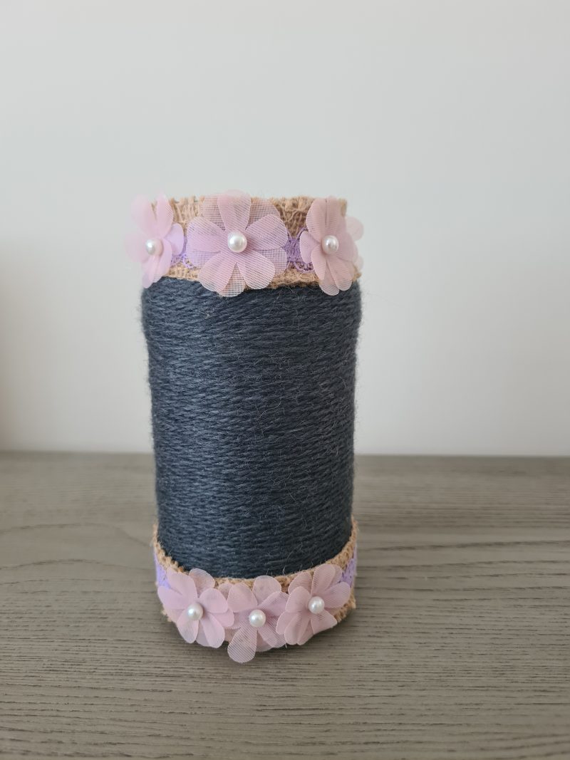 Upcycled glass jar. Wrapped with dark grey yarn and pink flowers