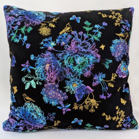 Front of Black cushion cover featuring colourful rainbow floral pattern with butterflies and gold accents, lined with a zip closure