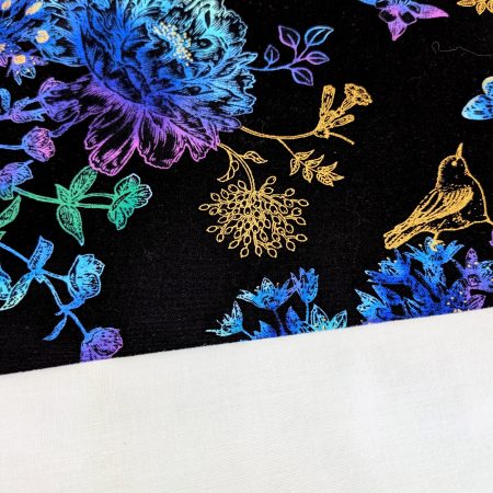 Lining detail of black cushion cover featuring colourful rainbow floral pattern with butterflies and gold accents, lined with a zip closure