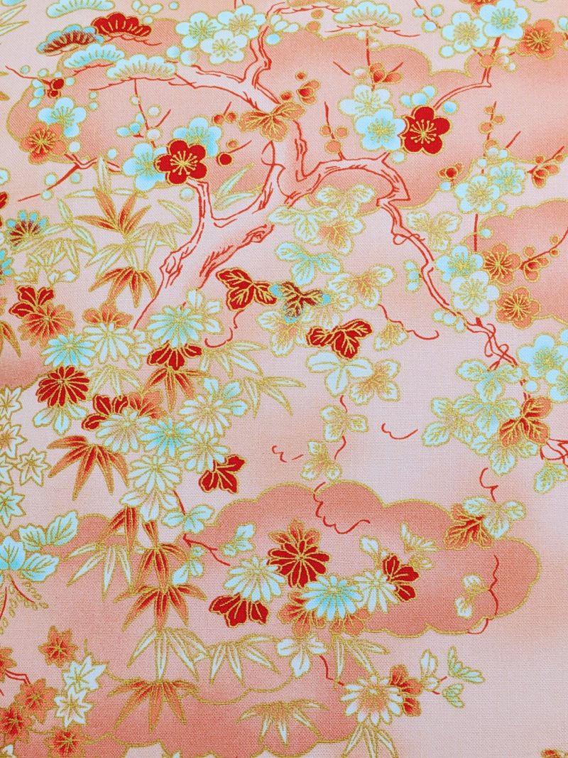 Detail of pale orange cushion cover with Japanese cherry blossom design and deeper orange cloud pattern, 18 inch with zip