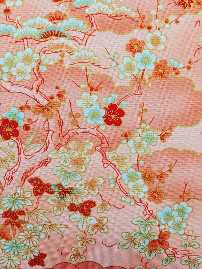 Detail of pale orange cushion cover with Japanese cherry blossom design and deeper orange cloud pattern, 18 inch with zip