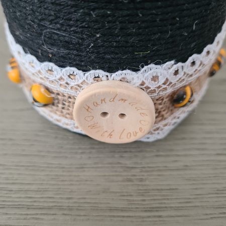 Upcycled wine bottle wrapped with yellow & black yarn with bumble bee decor