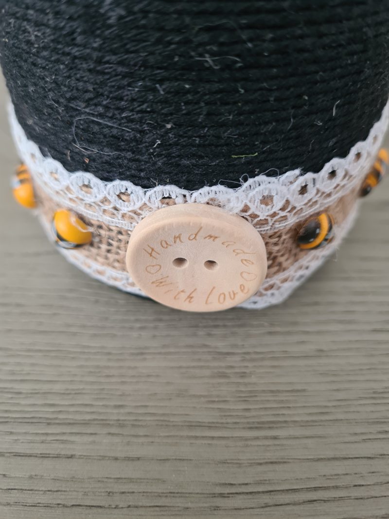 Upcycled wine bottle wrapped with yellow & black yarn with bumble bee decor