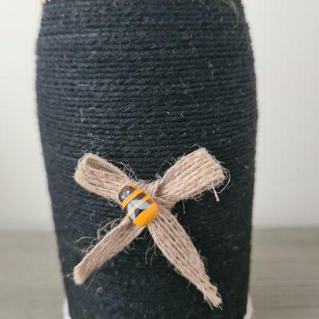 Upcycled wine bottle wrapped with yellow & black yarn with bumble bee decor