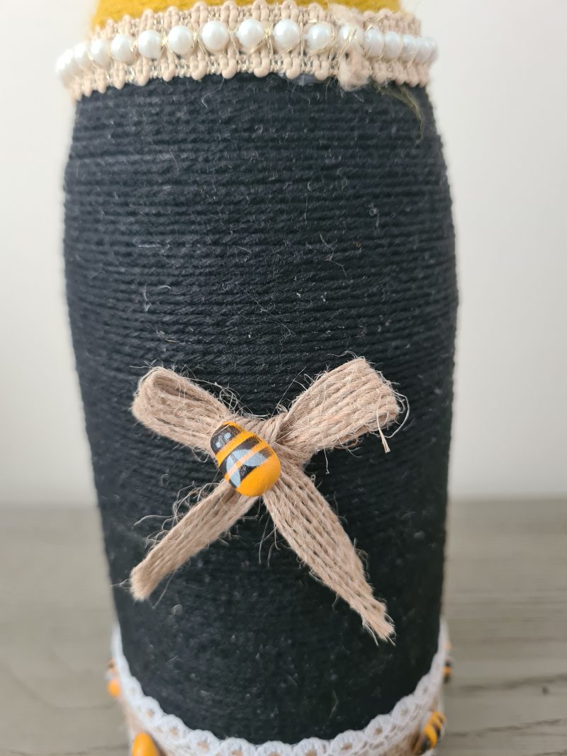 Upcycled wine bottle wrapped with yellow & black yarn with bumble bee decor