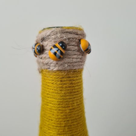 Upcycled wine bottle wrapped with yellow & black yarn with bumble bee decor