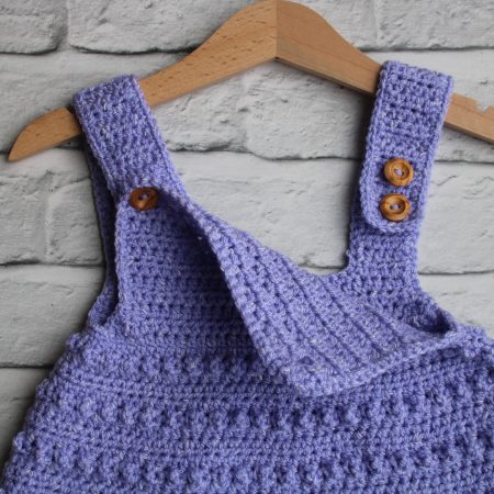 Button Fastening of Crochet Pinafore Style Dress for a Baby Girl