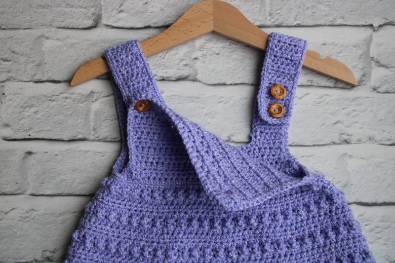 Button Fastening of Crochet Pinafore Style Dress for a Baby Girl