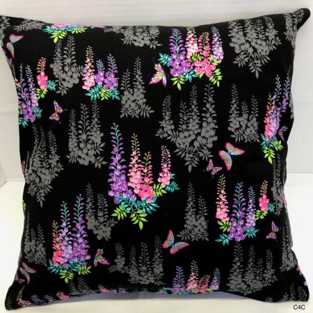 Front of black cushion cover with bright pink and purple floral pattern and butterflies, 18 inch square, lined with zip fastening