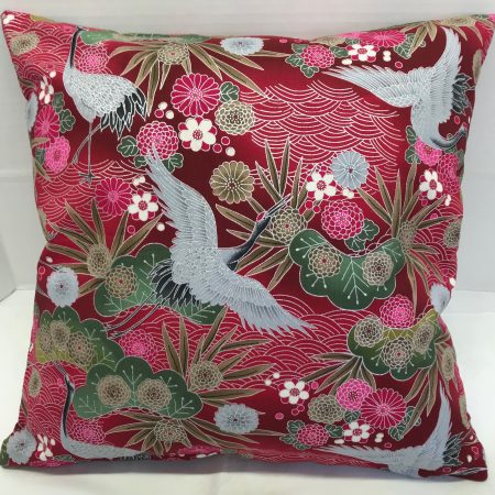 Front of red cushion cover with Japanese crane and floral pattern, featuring flying cranes and detailed blossoms on decorative fabric