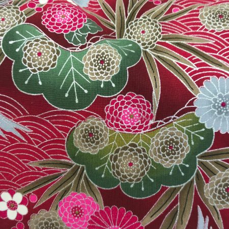 Reverse detail of red cushion cover with Japanese crane and floral pattern, featuring flying cranes and detailed blossoms on decorative fabric