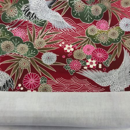 Lining detail of red cushion cover with Japanese crane and floral pattern, featuring flying cranes and detailed blossoms on decorative fabric