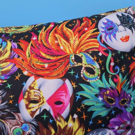 Detail of colourful cushion cover with vibrant carnival masks and feather design on a black background