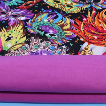 Lining detail of colourful cushion cover with vibrant carnival masks and feather design on a black background