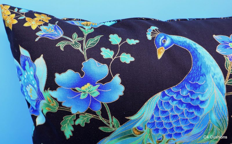 Peacock detail of blue peacock floral cushion cover with vibrant bird design on the front and feather pattern on the reverse