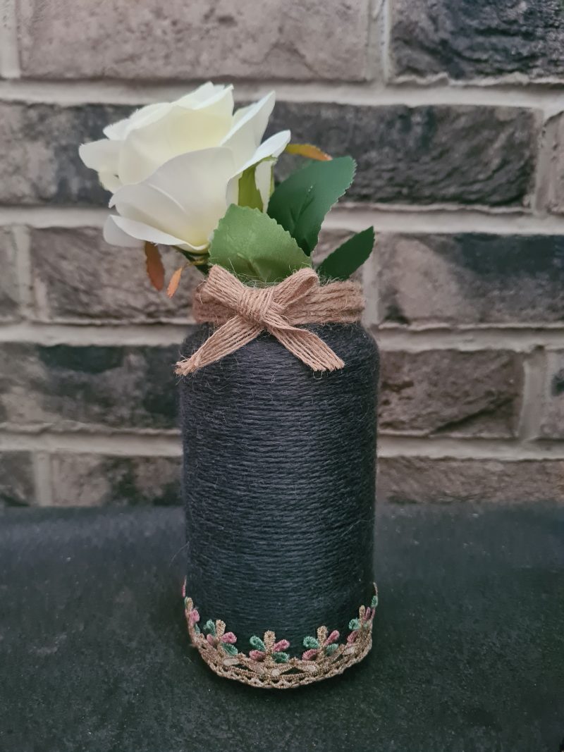 Upcycled glass jar wrapped in dark grey yarn with lace and jute trim