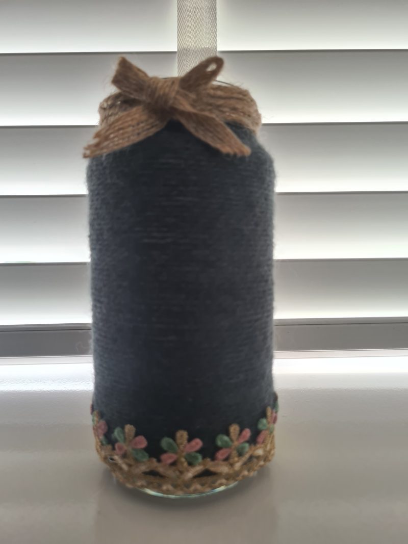 Upcycled glass jar wrapped in dark grey yarn with lace and jute trim