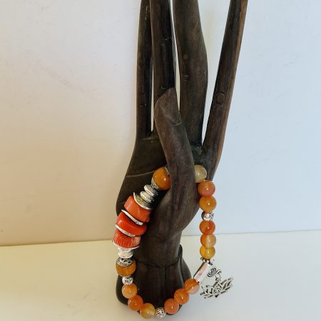 Stretch charm bracelet featuring deep sea coral, carnelian and Tibetan silver