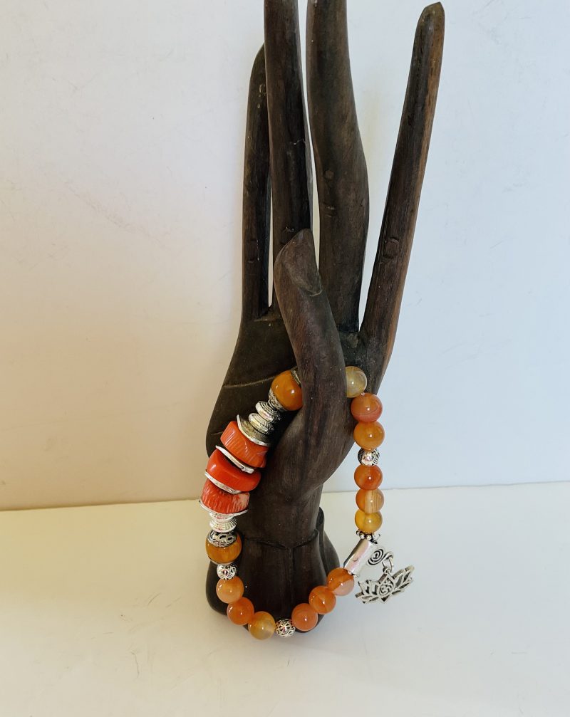 Stretch charm bracelet featuring deep sea coral, carnelian and Tibetan silver