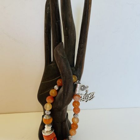 Stretch charm bracelet featuring deep sea coral, carnelian and Tibetan silver