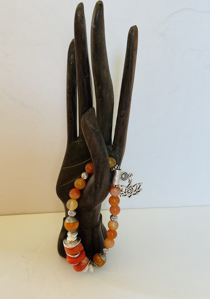 Stretch charm bracelet featuring deep sea coral, carnelian and Tibetan silver