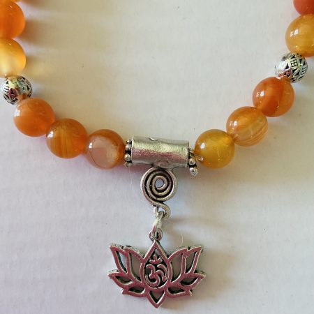 Stretch charm bracelet featuring deep sea coral, carnelian and Tibetan silver