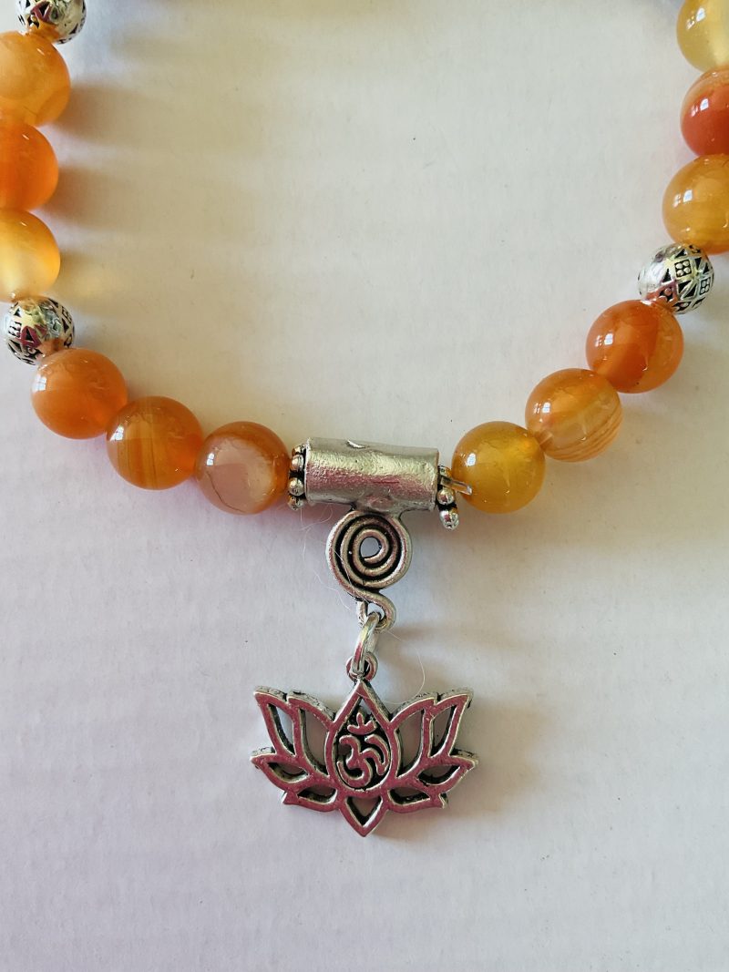 Stretch charm bracelet featuring deep sea coral, carnelian and Tibetan silver