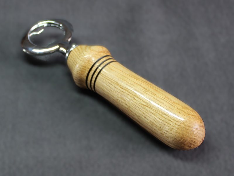 Hand turned oak bottle opener with a stainless steel opener