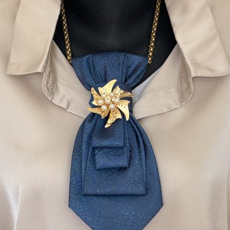 Handmade, elegant blue necktie accessory adorned by a beautiful golden flower brooch.