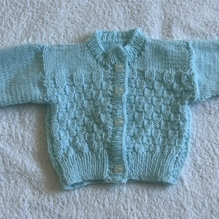 Hand knitted blue baby cardigan .