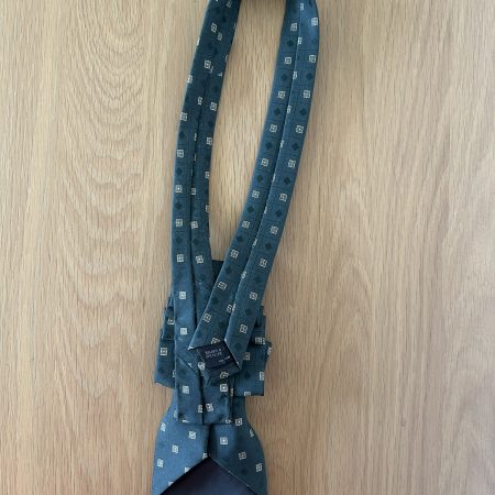 Pendant Elegant dark green patterned silk tie accessory adorned with a golden brooch