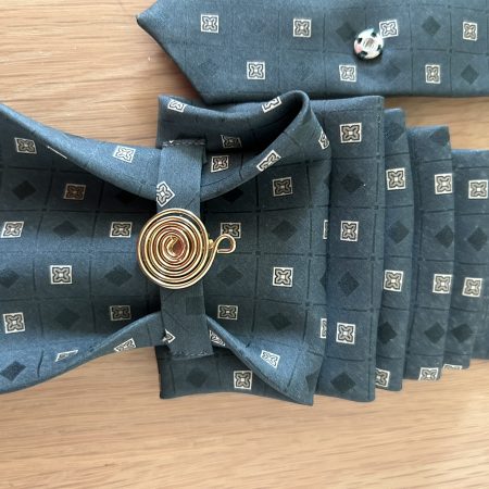 Pendant Elegant dark green patterned silk tie accessory adorned with a golden brooch