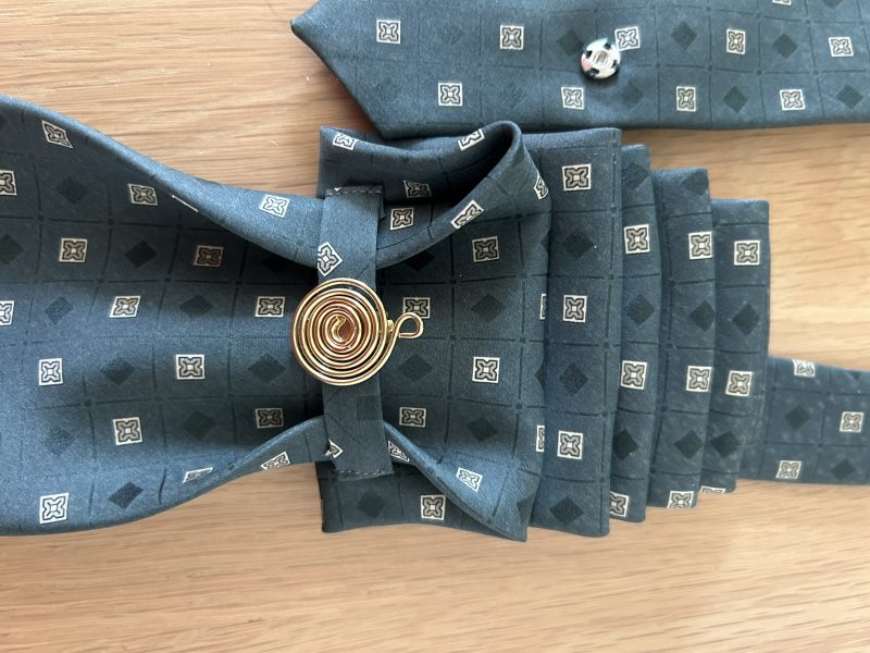 Pendant Elegant dark green patterned silk tie accessory adorned with a golden brooch