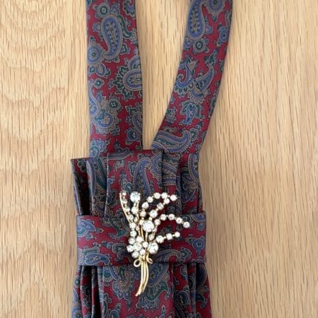 Stylish Handmade necktie accessory in a vintage-style burgundy paisley printed silk tie paired with a crystal floral brooch