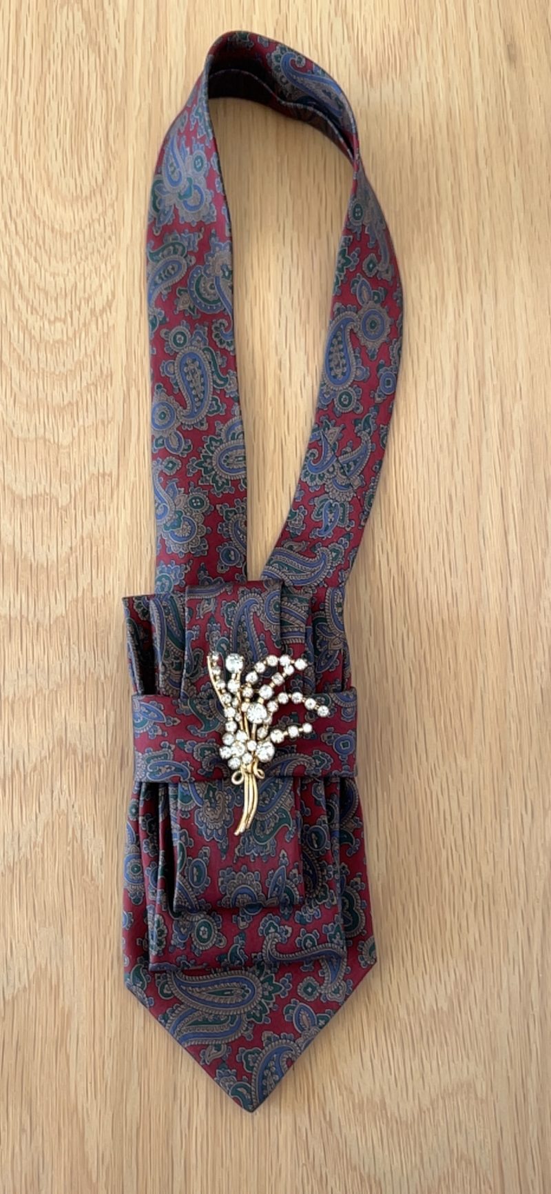 Stylish Handmade necktie accessory in a vintage-style burgundy paisley printed silk tie paired with a crystal floral brooch