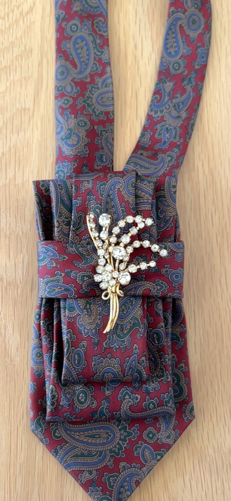 Stylish Handmade necktie accessory in a vintage-style burgundy paisley printed silk tie paired with a crystal floral brooch