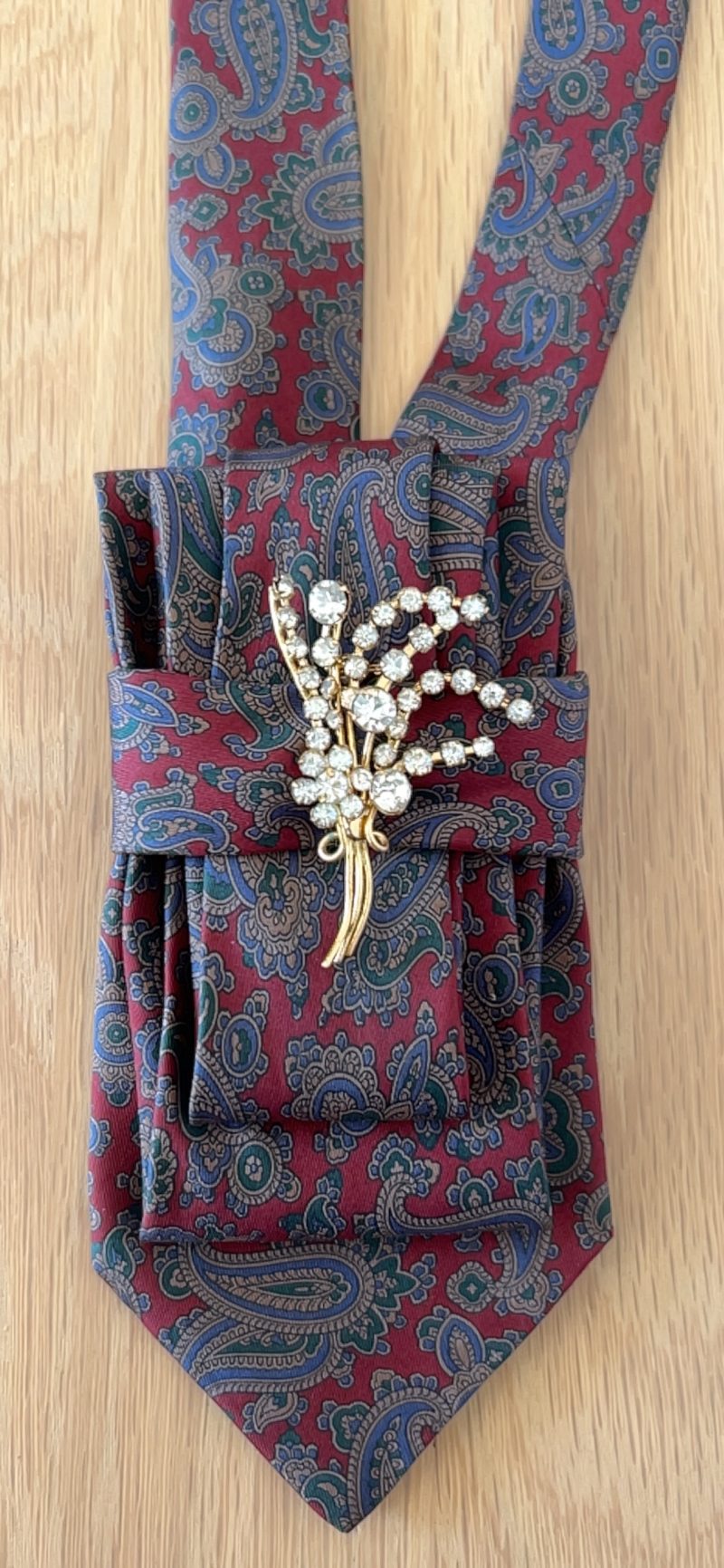 Stylish Handmade necktie accessory in a vintage-style burgundy paisley printed silk tie paired with a crystal floral brooch