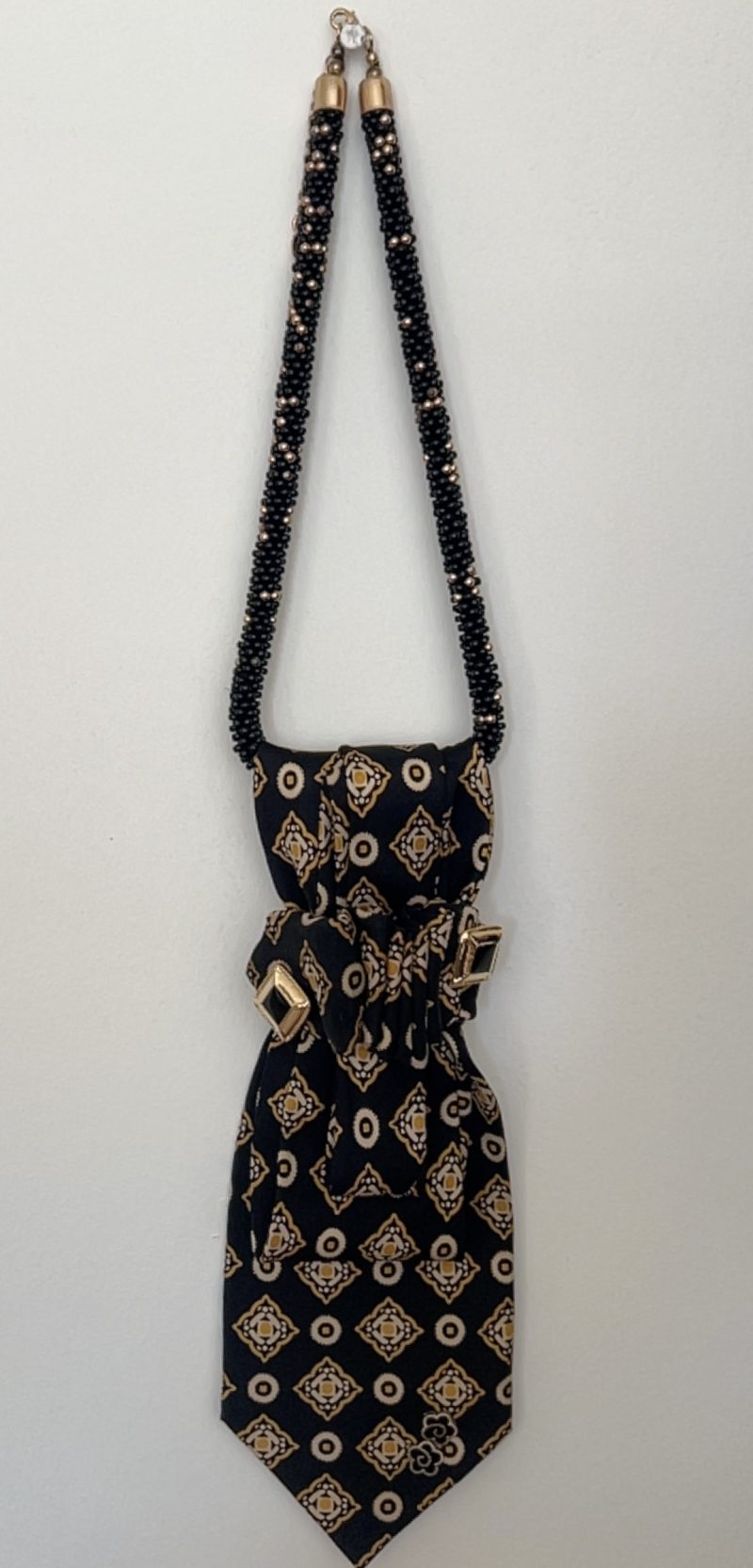 Handmade black silk necktie with a gold and white geometric pattern and decorative gold accents necktie.