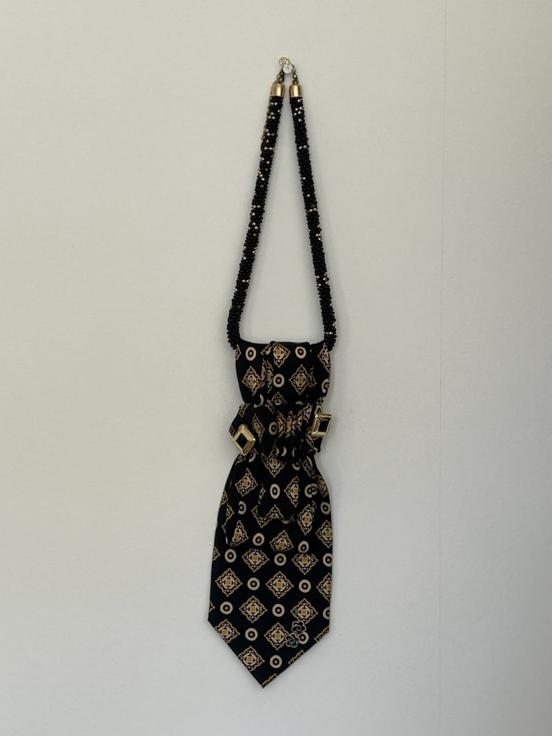 Handmade black silk necktie with a gold and white geometric pattern and decorative gold accents necktie.