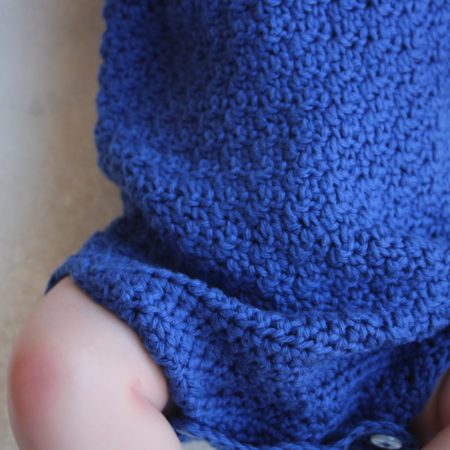 View of the textured stitch around the middle of the blue cotton baby romper
