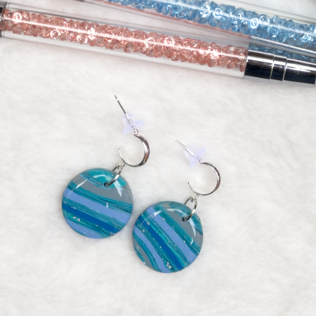 Small, circle polymer clay earrings in various colours.