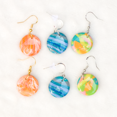 Small, circle polymer clay earrings in various colours.