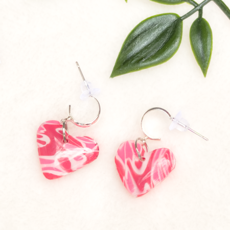 Small, heart shaped polymer clay earrings in various colours.