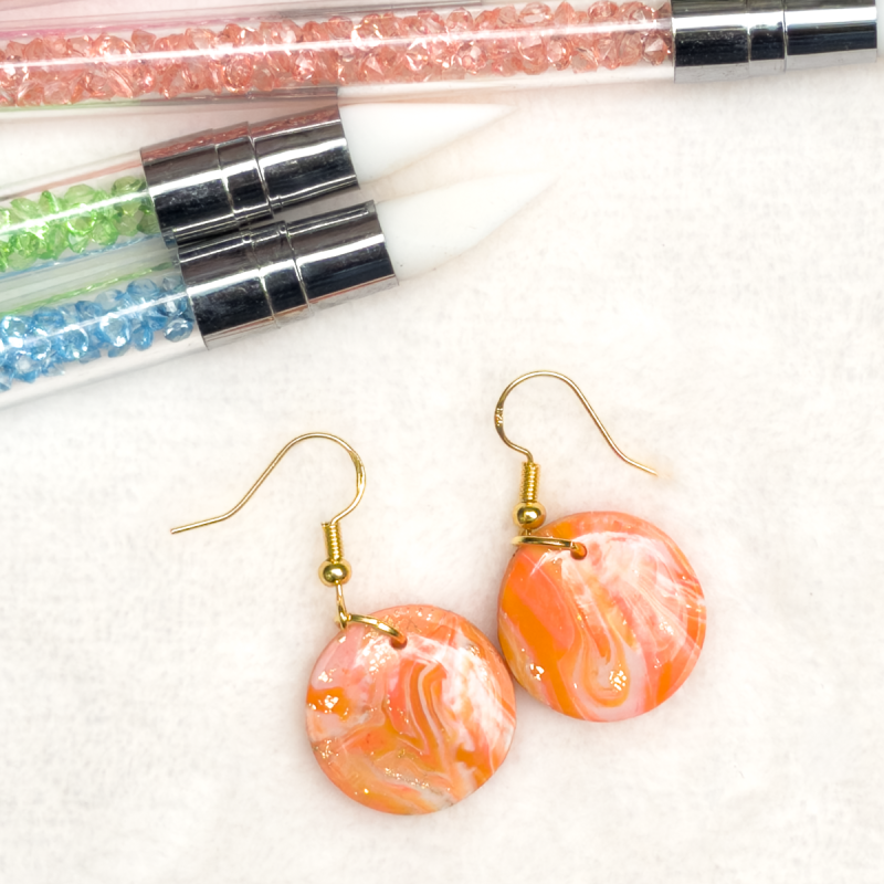 Small, circle polymer clay earrings in various colours.